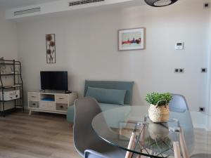 a living room with a glass table and a tv at Apartamento Servet, parking gratuito in Bormujos