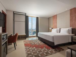 A bed or beds in a room at Hotel Santika Premiere Gubeng Surabaya