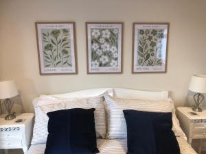 a bedroom with three pictures above a bed with pillows at The Studio in Harrogate