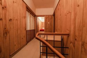 a hallway with wood paneled walls and a staircase at Vivera Highlands in Kodaikānāl