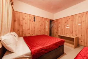 a bedroom with a red bed with wooden walls at Vivera Highlands in Kodaikānāl