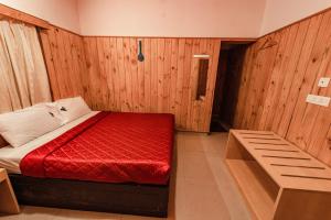 a bedroom with a bed with a red comforter at Vivera Highlands in Kodaikānāl