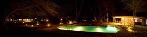 uma piscina com luzes num quintal à noite em NSYA CAMP MANYARA em Mto wa Mbu