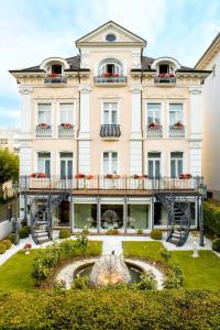 un edificio con una fuente frente a él en Hotel Villa am Kurpark, en Bad Homburg vor der Höhe