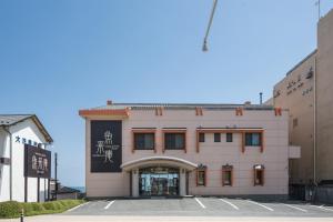 un edificio rosa con scrittura sul lato di Oarai Hotel Annex Gyoraian a Ōarai