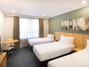 Giường trong phòng chung tại Mercure Sydney Macquarie Park