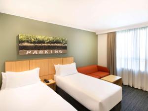 Giường trong phòng chung tại Mercure Sydney Macquarie Park