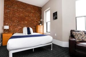 una camera con letto e muro di mattoni di Stylish Studio in Boston Brownstone, C.Ave #21 a Boston