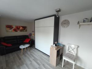 una sala de estar con un sofá negro y una gran puerta corredera de cristal en Appartement Studio Wenduine, en De Haan