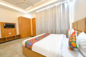 a bedroom with a large bed and a television at FabHotel Flying Kiwi in Mohali