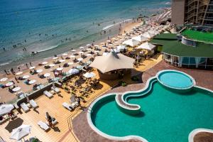 een uitzicht over een strand met een zwembad en de oceaan bij MPM Hotel Arsena - Ultra All Inclusive in Nesebar