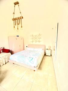 een slaapkamer met een bed en een kroonluchter bij Relax House in Bari