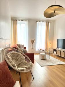 a living room with a couch and a chair at Appartement avec magnifique vue sur la Saône et son balcon in Chalon-sur-Saône