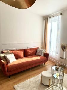 a living room with a brown couch and a table at Appartement avec magnifique vue sur la Saône et son balcon in Chalon-sur-Saône