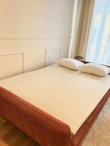 a bed with two pillows on it in a room at Appartement avec magnifique vue sur la Saône et son balcon in Chalon-sur-Saône