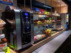 eine Bäckerei mit Kühlschrank in einem Laden mit Essen in der Unterkunft Ibis Budget Le Havre Les Docks in Le Havre