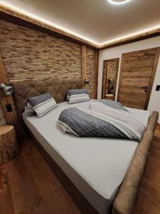 ein großes Bett mit zwei Kissen darauf in einem Zimmer in der Unterkunft Luxus-Apartment-Vorderreit Gut in Altenmarkt im Pongau