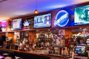 een bar met veel flessen alcohol en televisies bij Mardi Gras Hotel & Casino in Las Vegas