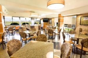 um restaurante com mesas, cadeiras e janelas em Drury Inn & Suites Paducah em Paducah