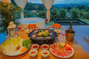 einen Tisch mit Speisen und Weinen in der Unterkunft เฌอปือ เชียงใหม่ Cherpue Chiangmai 