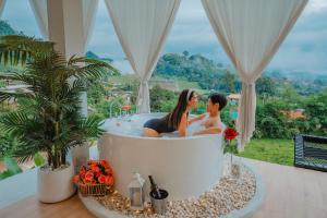 ein Paar in einer Badewanne in einem Zimmer mit Aussicht in der Unterkunft เฌอปือ เชียงใหม่ Cherpue Chiangmai 