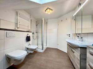 bagno bianco con servizi igienici e lavandino di Ferienapartment Huber a Oberkirch