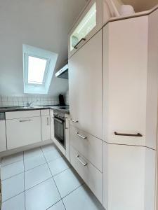 una cucina bianca con armadi bianchi e una finestra di Ferienapartment Huber a Oberkirch