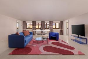 a living room with a blue couch and a red rug at Palazzo Dei Fiori by Room Mate in Venice