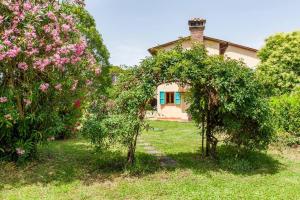 une maison avec des arbres et des fleurs dans la cour dans l'établissement Podere l'Ulivo, à San Miniato