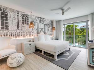 a bedroom with a white bed and a chair at SLS at Baha Mar in Nassau