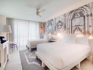 a white bedroom with a bed and a couch at SLS at Baha Mar in Nassau