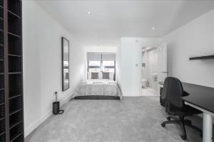 - une chambre blanche avec un lit et un bureau dans l'établissement Sandmere Road by CAPITAL, à Londres