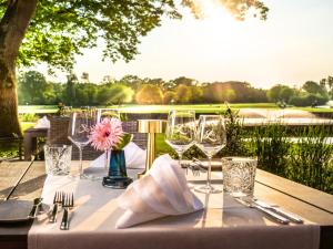 stół z kieliszkami do wina i widokiem na pole golfowe w obiekcie Steigenberger Hotel Treudelberg Hamburg w mieście Hamburg