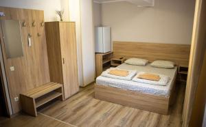 a small bedroom with a bed and a refrigerator at Каприз in Kamianets-Podilskyi