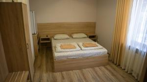 a small bedroom with a bed with two towels on it at Каприз in Kamianets-Podilskyi