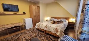 a bedroom with a bed with a teddy bear on it at Hotel Senlīči in Jelgava