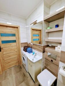 a small bathroom with a washing machine and a sink at Sea Suite, 150 meters to beach, Baltic Best in Dziwnówek