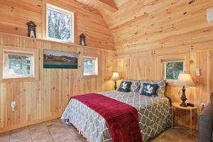 1 dormitorio con 1 cama en una habitación de madera en Avonlea Forest Hill Cottages, en New Glasgow