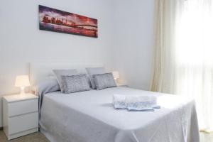 um quarto branco com uma cama branca e uma mesa branca em New Reus Mediterrani em Vilafortuny