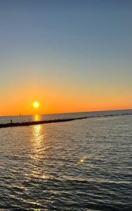 a sunset over the ocean with the sun setting at Sweet Home FCO Airport Roma in Fiumicino