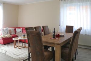 sala de estar con mesa de madera y sillas en Apartment Am Mittelpunkt Deutschlands, en Niederdorla