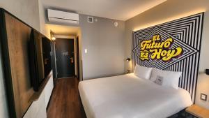 リマにあるibis styles Lima San Isidroのベッドルーム1室(白いベッド1台、壁に看板付)