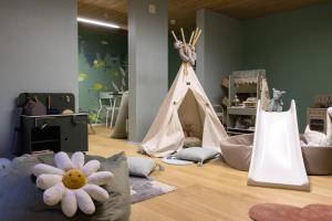 Habitación infantil con sala de juegos con tienda en Hotel Adula, en Flims