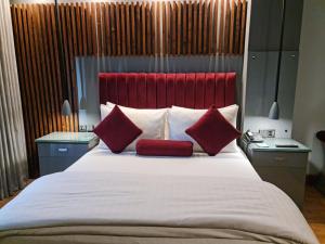 1 cama grande con cabecero rojo y almohadas rojas en Hotel Crown Plaza Islamabad, en Islamabad