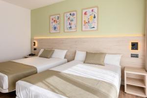 two beds in a hotel room with two beds at Hotel Jaime I in Salou