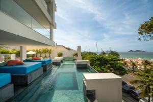 una piscina a sfioro in una casa con vista sull'oceano di Lifestyle Laghetto Collection a Rio de Janeiro