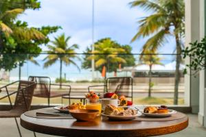 un tavolo con piatti di cibo sopra con vista sulla spiaggia di Lifestyle Laghetto Collection a Rio de Janeiro