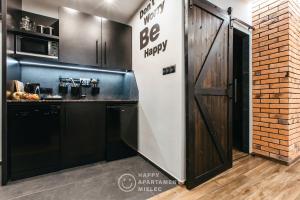 a kitchen with a be happy sign next to a door at Happy Night - ApartamentyHappy pl in Mielec