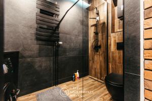 a bathroom with a toilet and a glass shower at Happy Night - ApartamentyHappy pl in Mielec