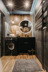 a bathroom with a washing machine and a mirror at Happy Night - ApartamentyHappy pl in Mielec